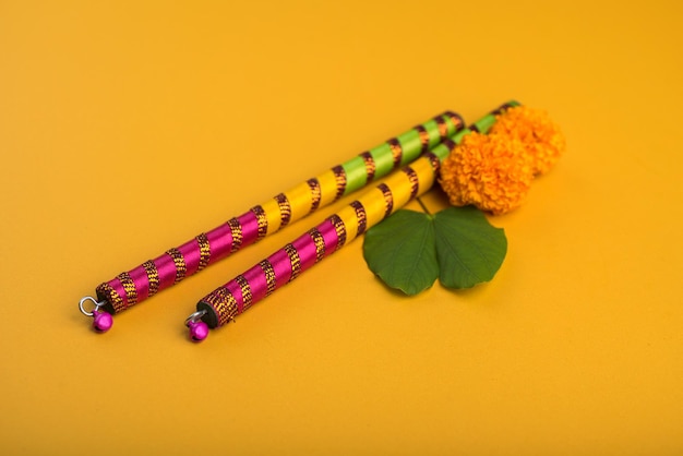 Foto vista ad alta angolazione di dandiya con marigold su sfondo giallo