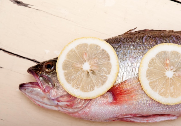 テーブルの上にレモンを置いた死んだ魚の高角度の視点
