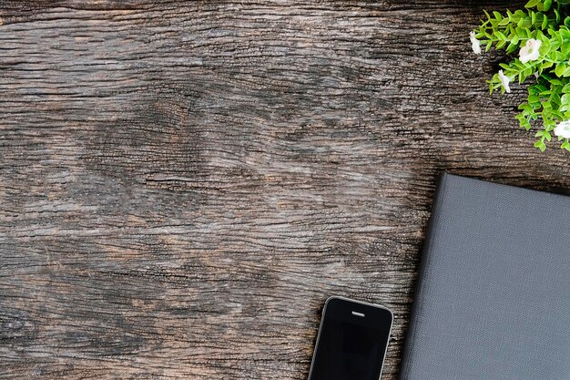 Photo high angle view of diary with mobile phone and potted plant on wooden table