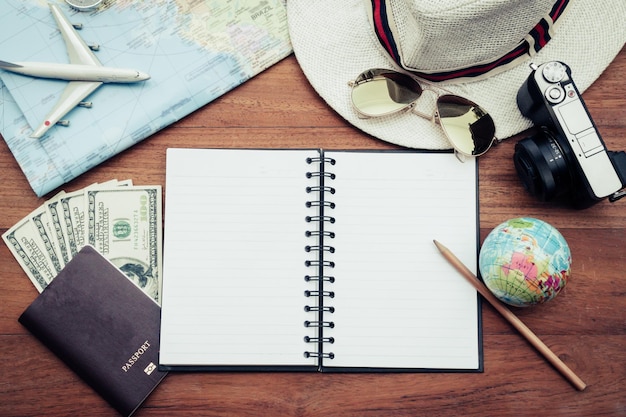 High angle view of diary with personal accessories and other equipment on wooden table