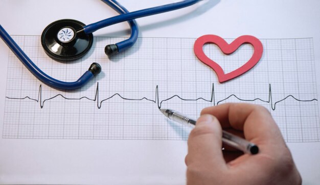 Photo high angle view of doctor analyzing pulse trace at desk in hospital