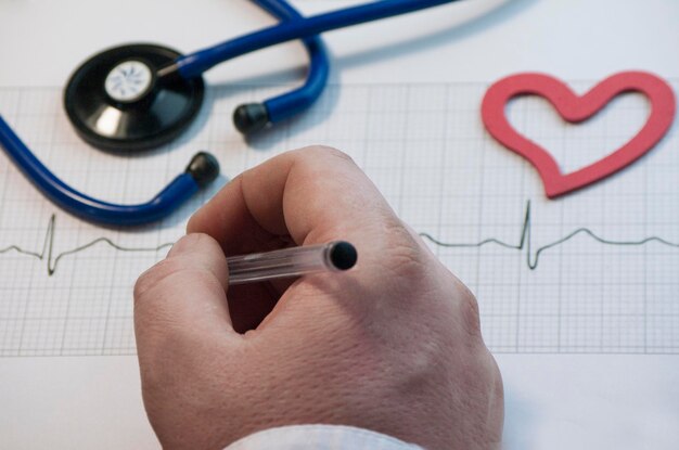 Foto vista ad alta angolazione del medico che analizza la traccia del polso alla scrivania in ospedale