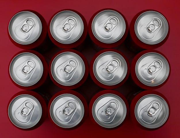 Photo high angle view of drink cans arranged on red table