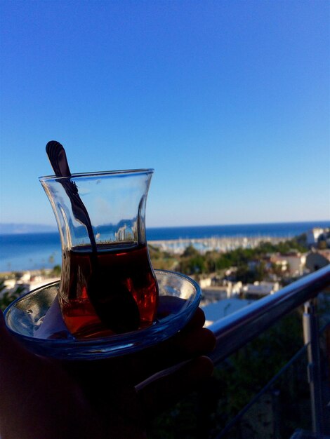 High angle view of drink on table by swimming pool against sky