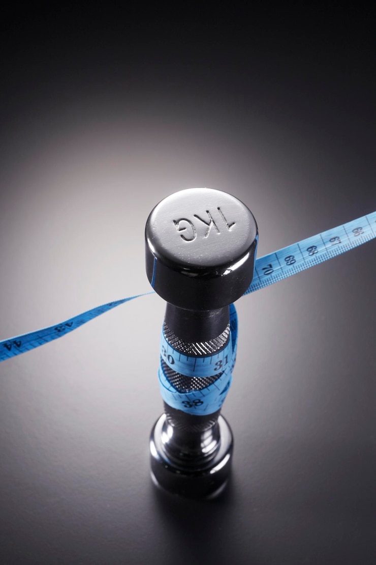 Photo high angle view of dumbbell with tape measure on table