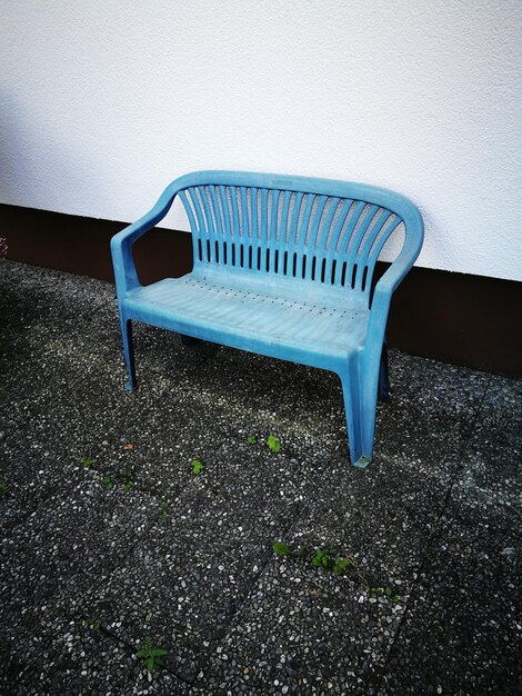 Photo high angle view of empty bench on field against wall