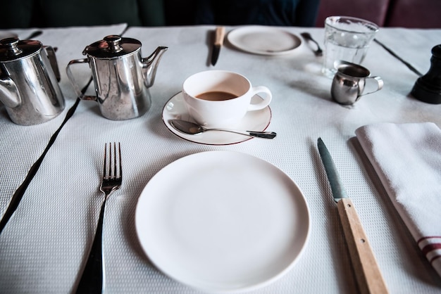 high angle view of empty plate by coffee and kettles on table