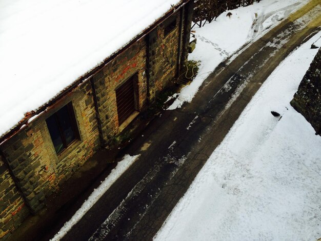 High angle view of empty road amidst snow covered buildings