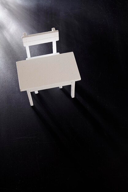 Foto vista ad alto angolo di tavolo e sedia vuoti su sfondo nero