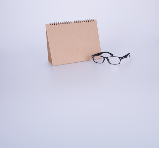 High angle view of eyeglasses on paper against white background