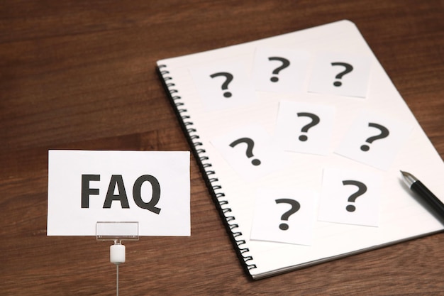 High angle view of faq text and question marks on table