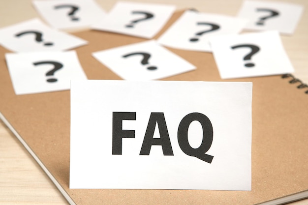 High angle view of faq text and question marks on table