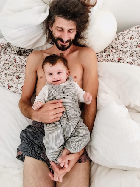 High angle view of father and daughter on bed