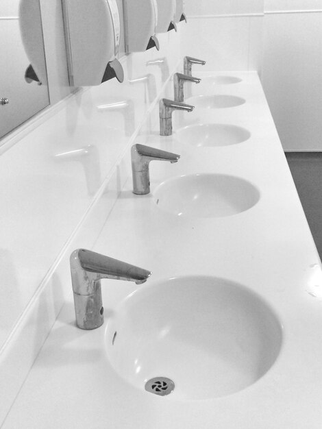 Photo high angle view of faucets in public restroom