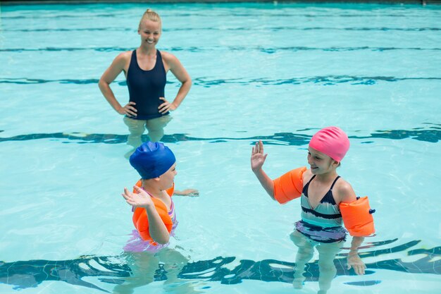 High angle view of female instructor and girls in swimming pool