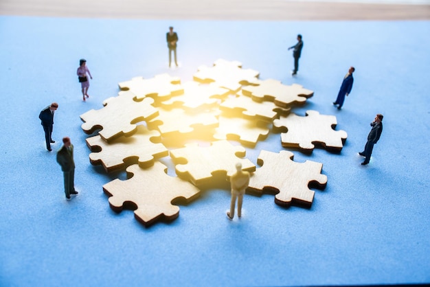 High angle view of figurines around wooden jigsaw pieces