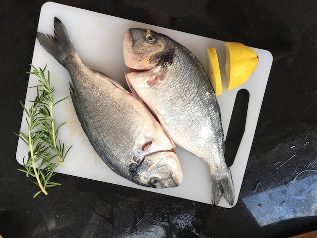 high angle view of fish on cutting board over table