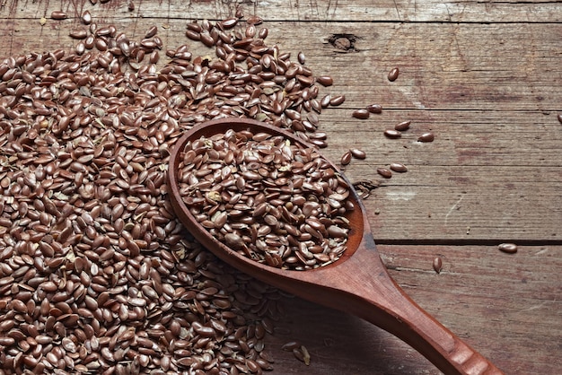 High angle view of flax seeds in wooden spoon on table
