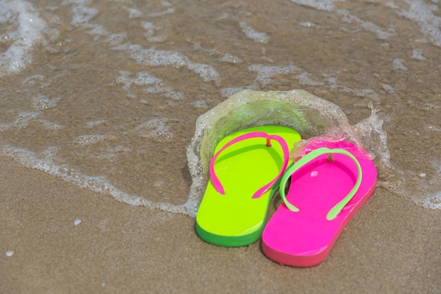 Foto vista ad alto angolo delle pantofole sulla spiaggia