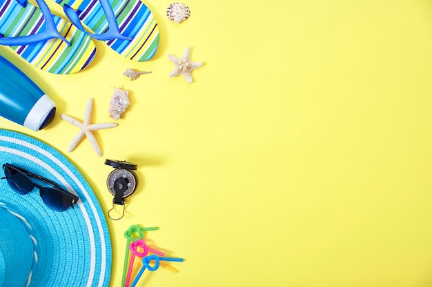 High angle view of flip flops and hat on yellow background