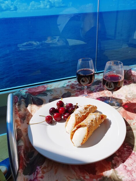 Foto vista ad alta angolazione del cibo e delle bevande sul tavolo dalla finestra di una barca in mare