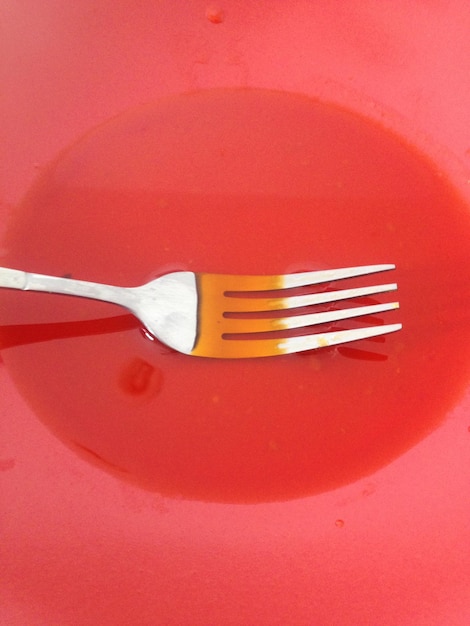 Photo high angle view of fork in juice on plate