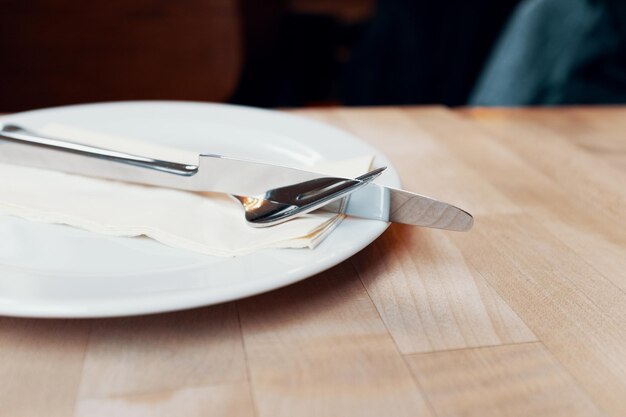 테이블 위의 빈 접시에서 포크와 테이블 칼의 높은 각도 시각.