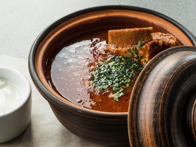 Photo high angle view of fresh borscht with veal ribs in bowl on table