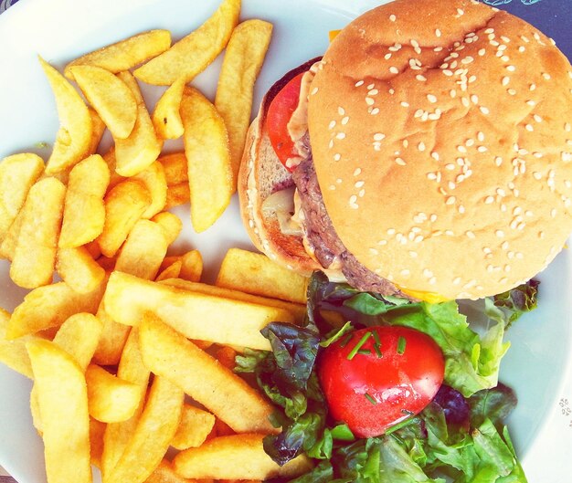 Foto vista ad alto angolo di un hamburger fresco con patatine fritte nel piatto