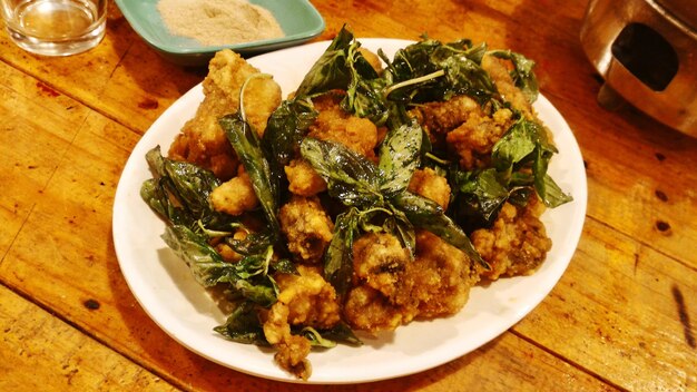 High angle view of fried oysters served in plate on wooden table