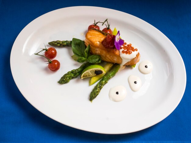 High angle view of fried trout with cream sauce and vegetables served on table