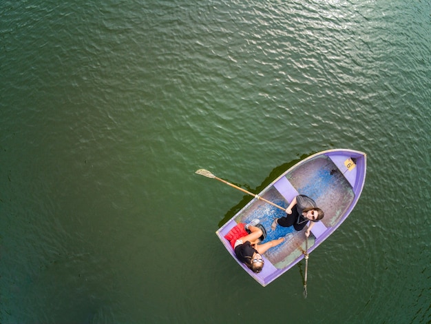 Photo high angle view of friends rowing boat on lake