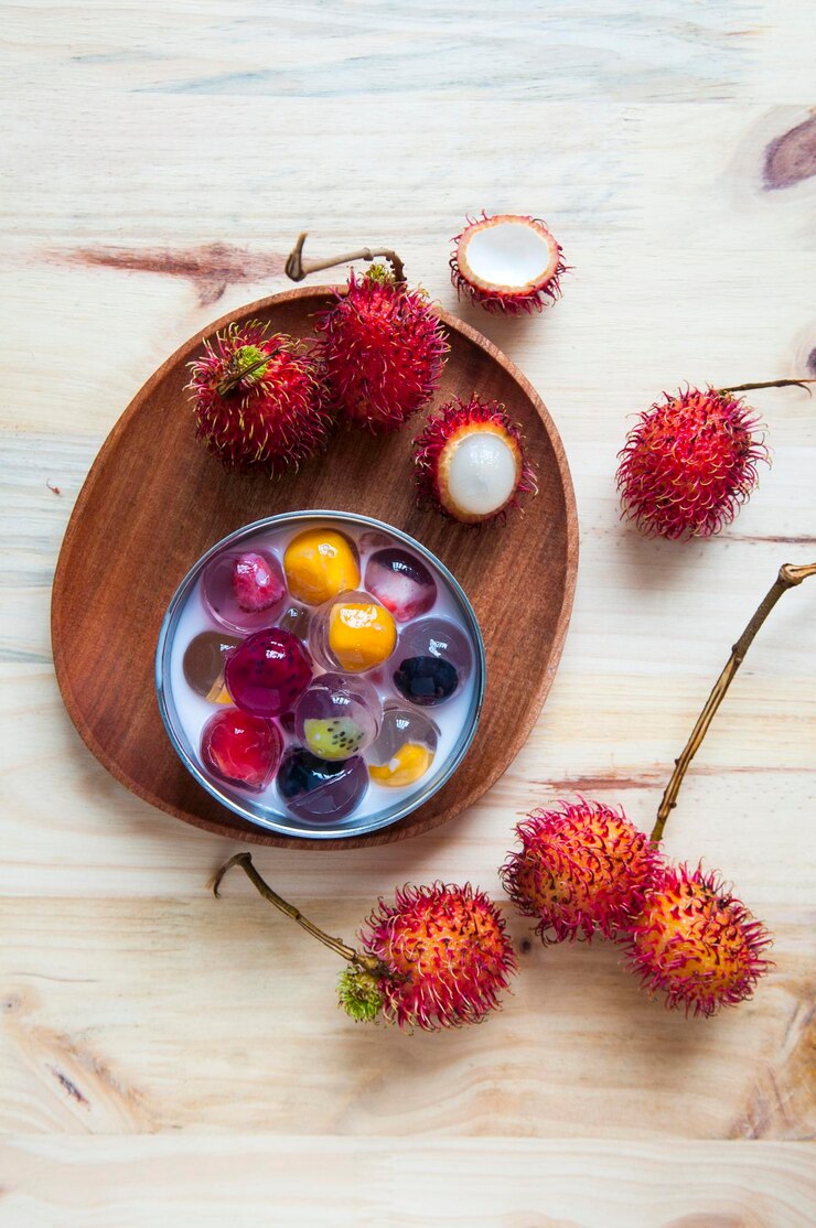 Photo high angle view of fruit jelly and rambutans on table