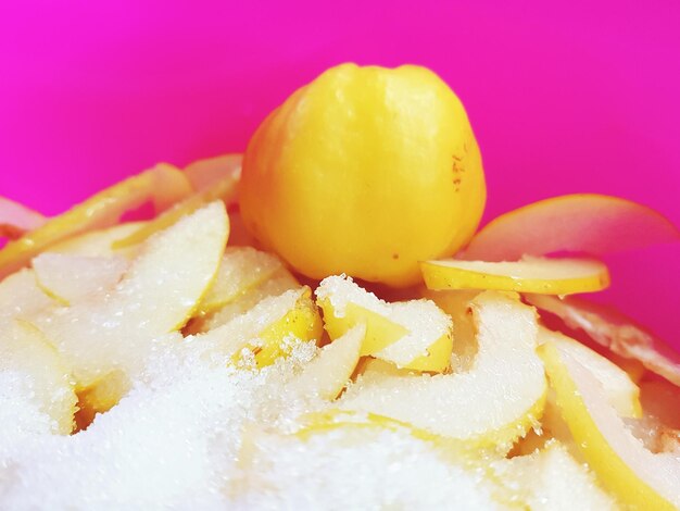 High angle view of fruit slices with sugar against pink background