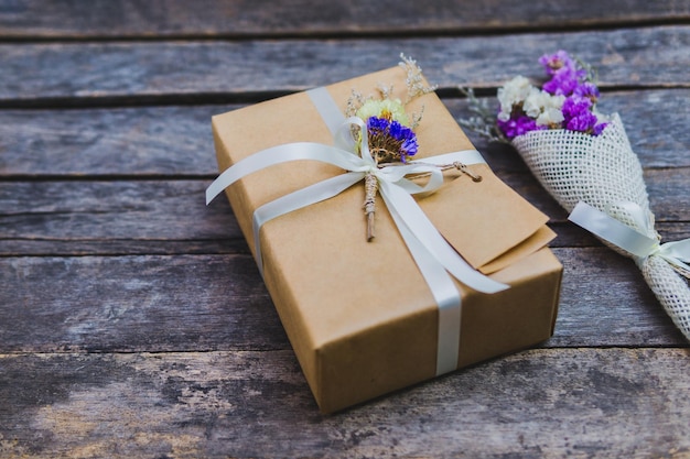 High angle view of gift with bouquet on table