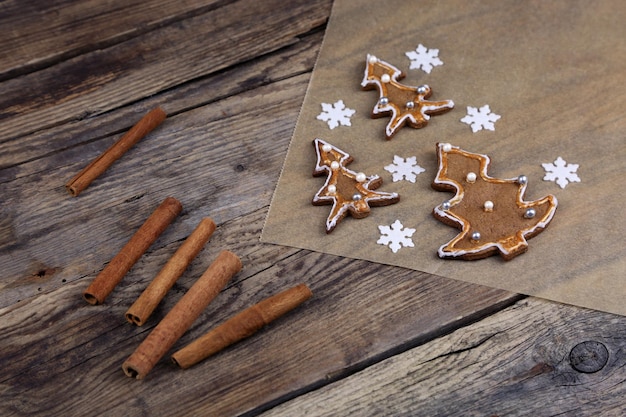 Photo high angle view of gingerbread cookies with cinnamon on wooden table during christmas