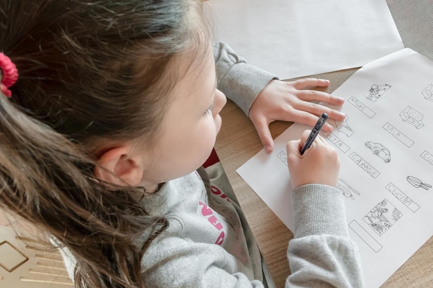 Photo high angle view of girl drawing on book at table