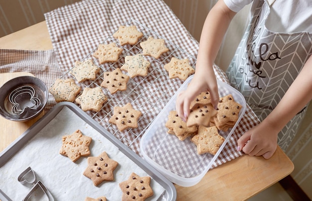 Photo high angle view of a girl holding cookies on cooling racks