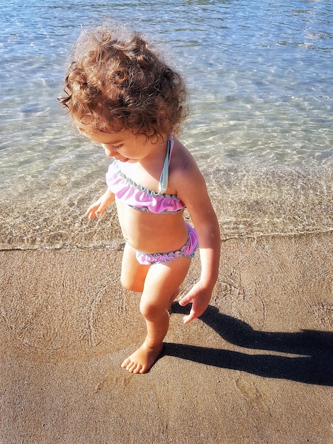 Foto vista ad alto angolo della ragazza sulla riva sulla spiaggia