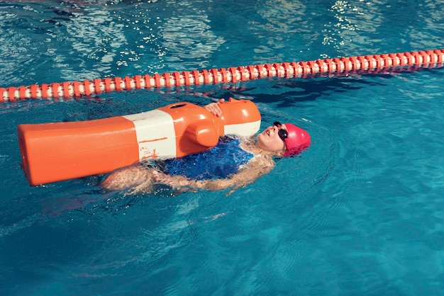 Foto vista ad alta angolazione di una ragazza che nuota con un manichino in piscina