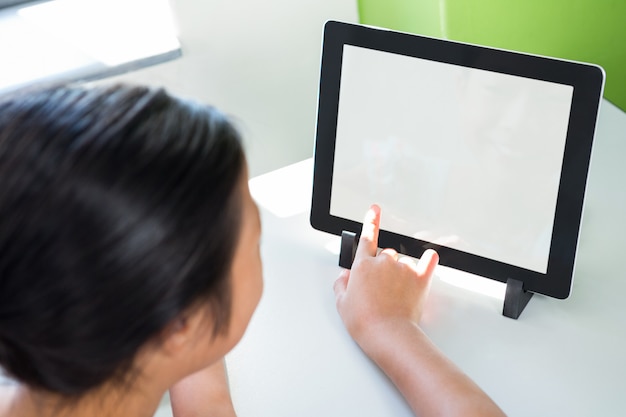 Vista dell'angolo alto della ragazza che per mezzo della compressa digitale