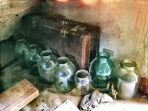 High angle view of glass jars and suitcase in abandoned room