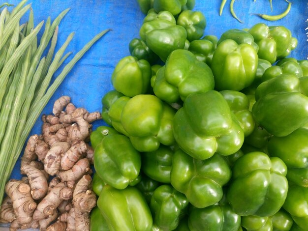 High angle view of green bell peppers and gingers at market for sale