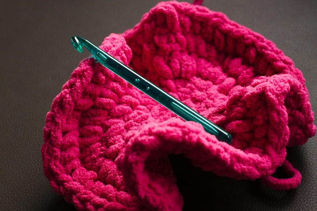 Foto vista ad alta angolazione dell'uncinetto verde sul cappello rosa sopra il tavolo