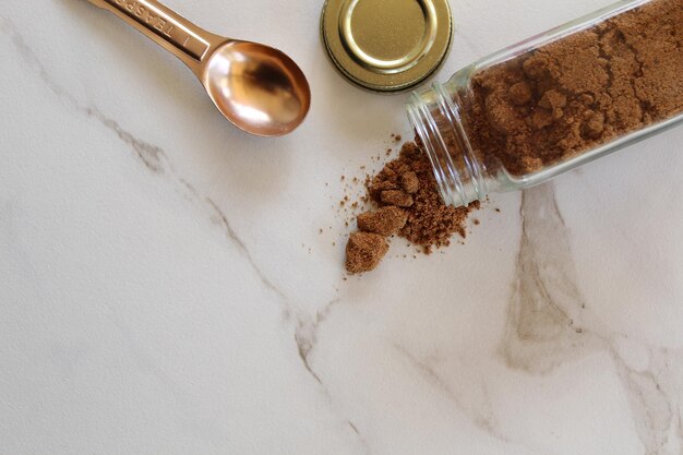 High angle view of ground coffee spilling from glass jar on kitchen counter