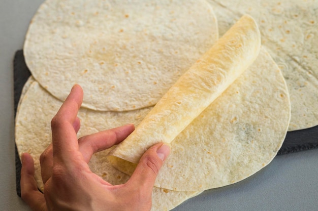 Foto vista ad alta angolazione della mano che tiene il pane sul tavolo