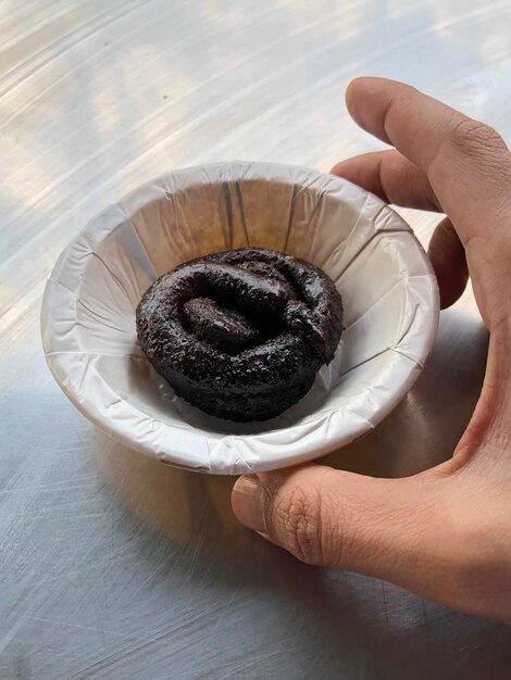 High angle view of hand holding ice cream on table