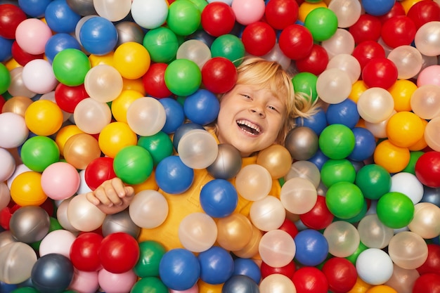 色のボールで遊ぶ幸せな少年の高角度ビュー