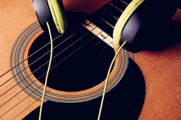 Photo high angle view of headphones on guitar