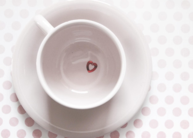 Photo high angle view of heart shape confetti in cup on table